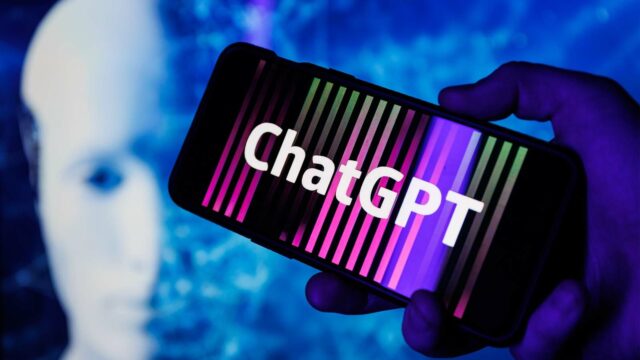 Foto: Shutterstock / Rokas Tenys. Bildet viser en telefon der det står ChatGPT på skjermen. En robot vises i bakgrunnen.